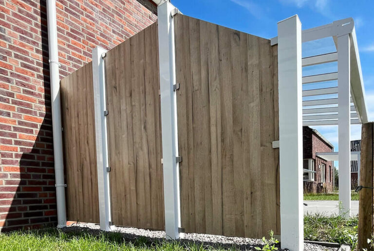 Dekorzaun mit Holzelemenenten und weißen Pfosten als Einfriedung