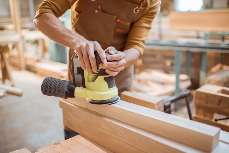 Tischler schleift Zaunpfosten aus Holz