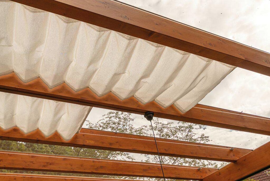 Seilspannmarkise als Sonnenschutz für eine Terrassenüberdachung aus Holz